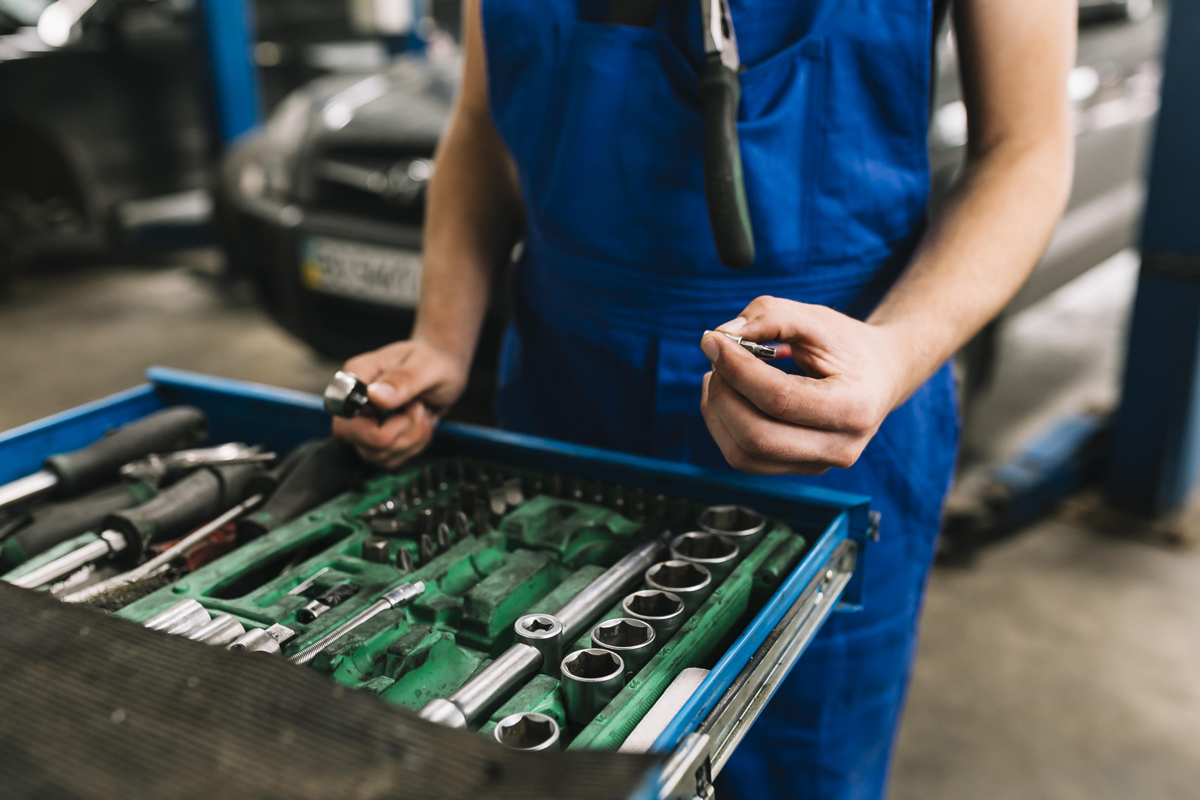 auto-mechanic-s-hand-holding-spanners foto-mecanico-mantenimiento-laminadoras